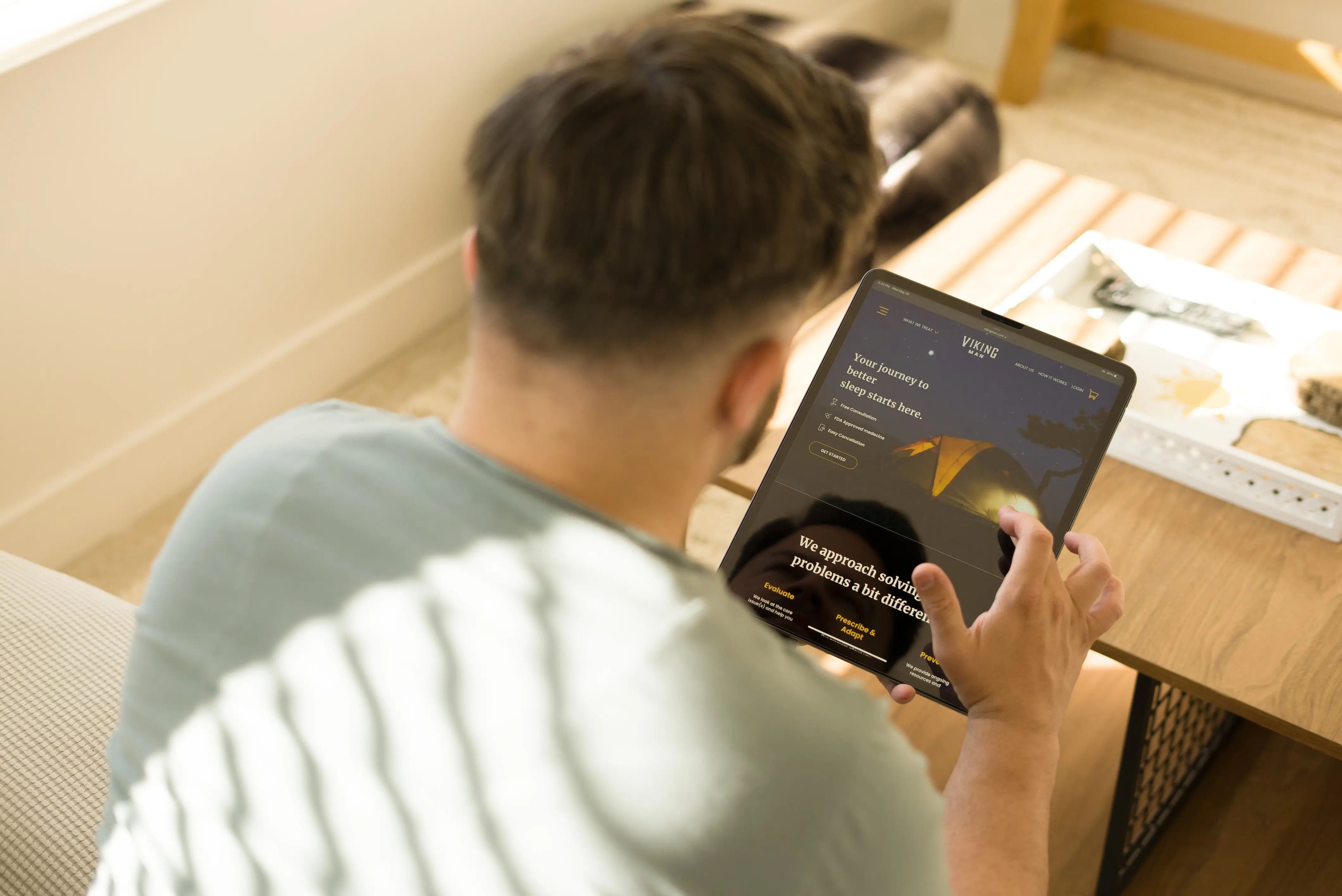 Man viewing the Viking Man website using his tablet while sitting on a couch
